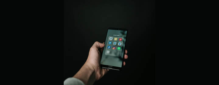 Bild på en hand som håller i en mobiltelefon.