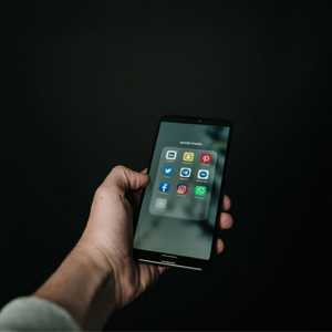 Bild på en hand som håller i en mobiltelefon.