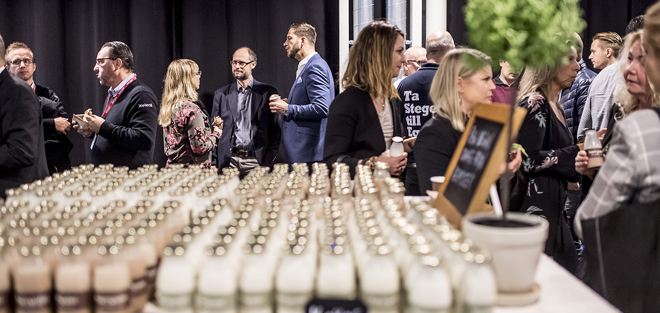 Personer i stor grupp som står och pratar i smågrupper