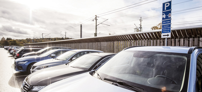 Bilar står parkerade vid parkeringsskylt.